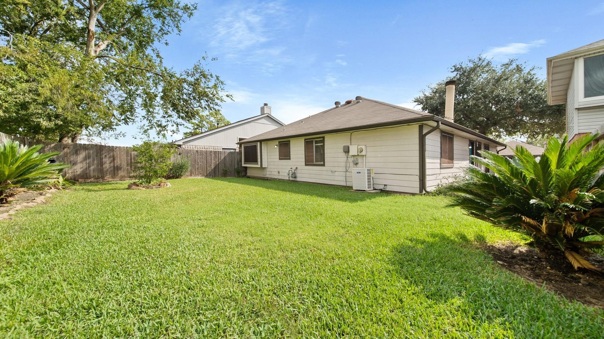 2012 Sandy Knoll Drive, Missouri City, TX 77489 Spacious backyard with a well-maintained lawn and mature landscaping.