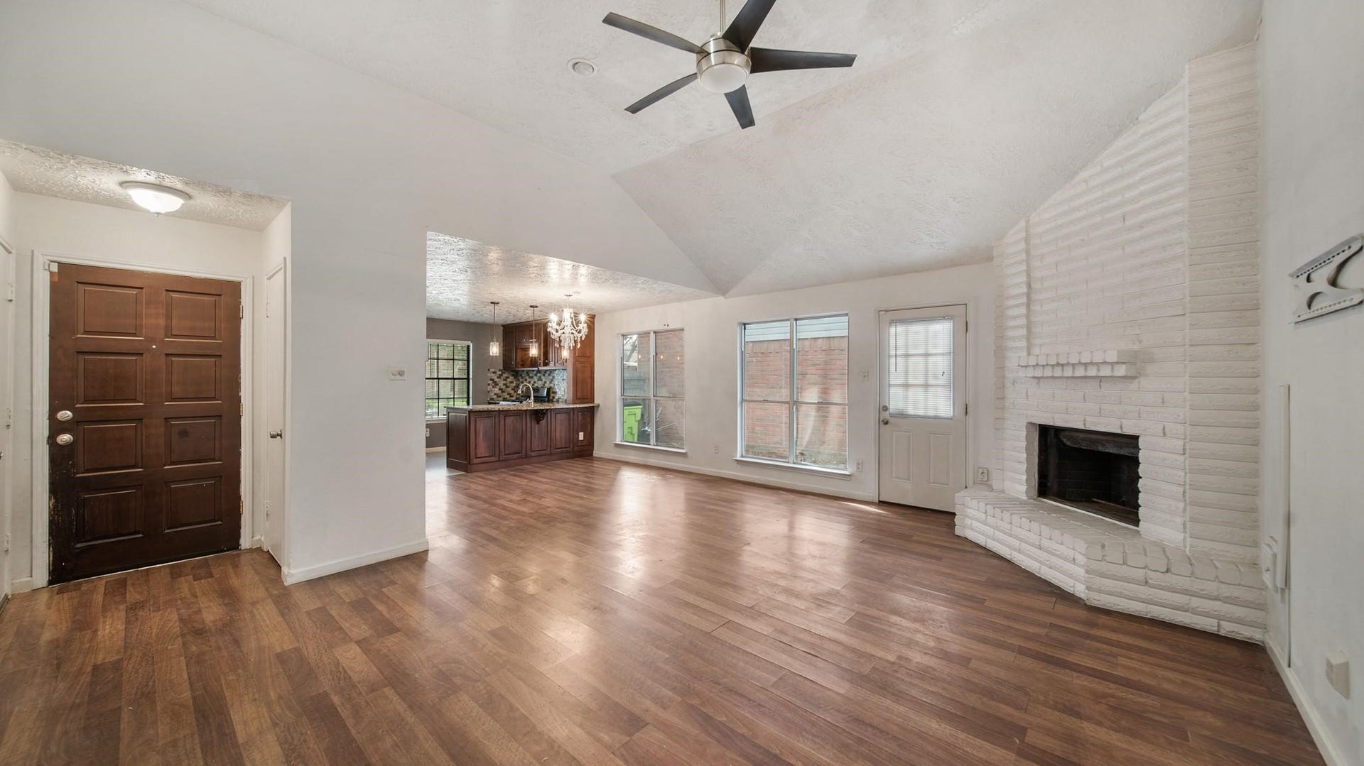 2012 Sandy Knoll Drive, Missouri City, TX 77489 Additional view of the open floorplan highlighting the fireplace, vaulted ceiling, and open layout to the dining and kitchen areas.