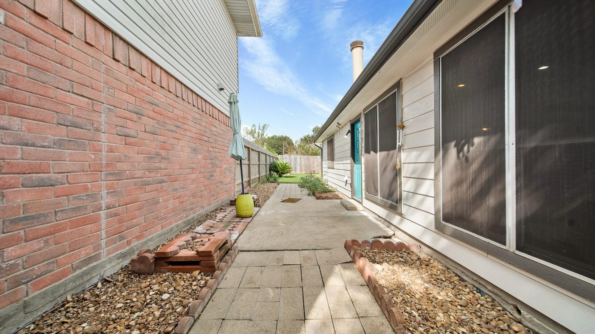 2012 Sandy Knoll Drive, Missouri City, TX 77489 Side patio area with paved walkway and low-maintenance landscaping.