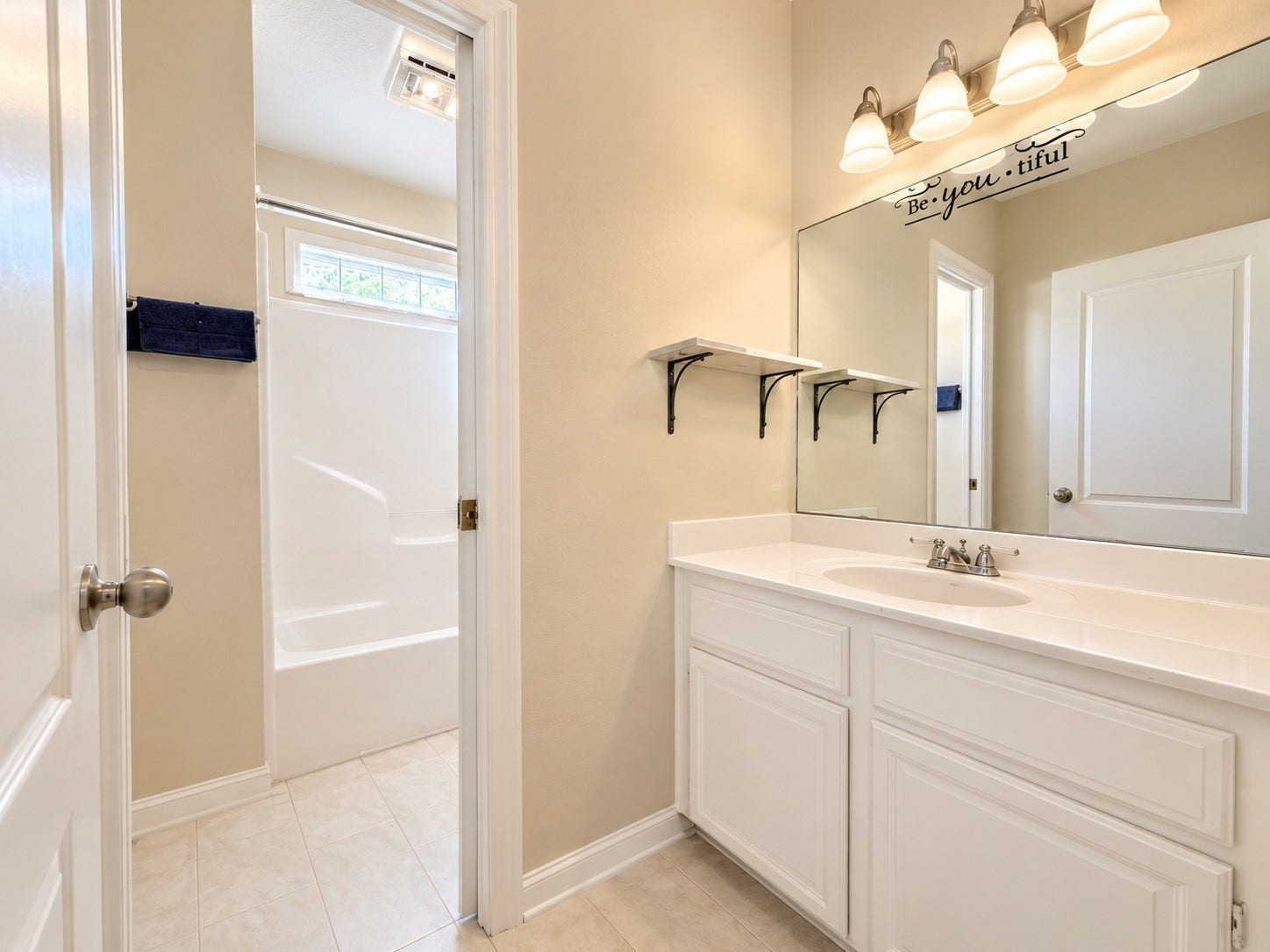 4030 Larkspur Street, Alvin, TX 77511 Bright and inviting secondary bathroom featuring a spacious vanity with ample storage, elegant lighting, and a convenient shower-tub combination with neutral tones.