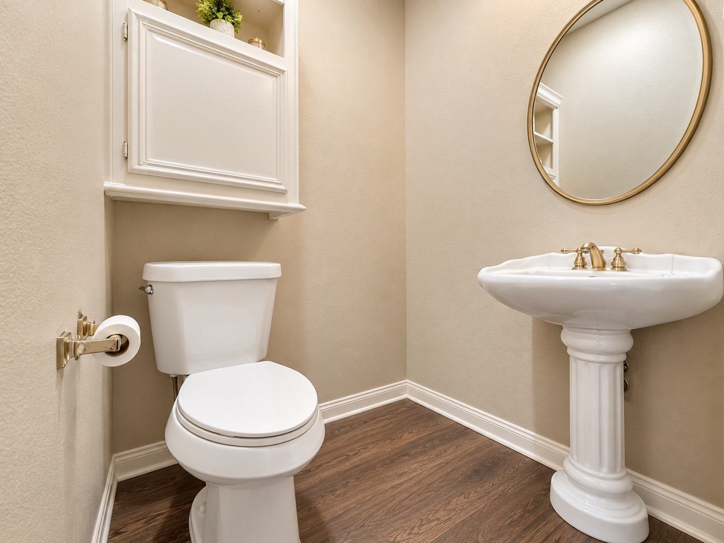 4030 Larkspur Street, Alvin, TX 77511 Charming powder room with elegant pedestal sink, sleek wood-look flooring, and a classic round mirror, complemented by a convenient storage cabinet.