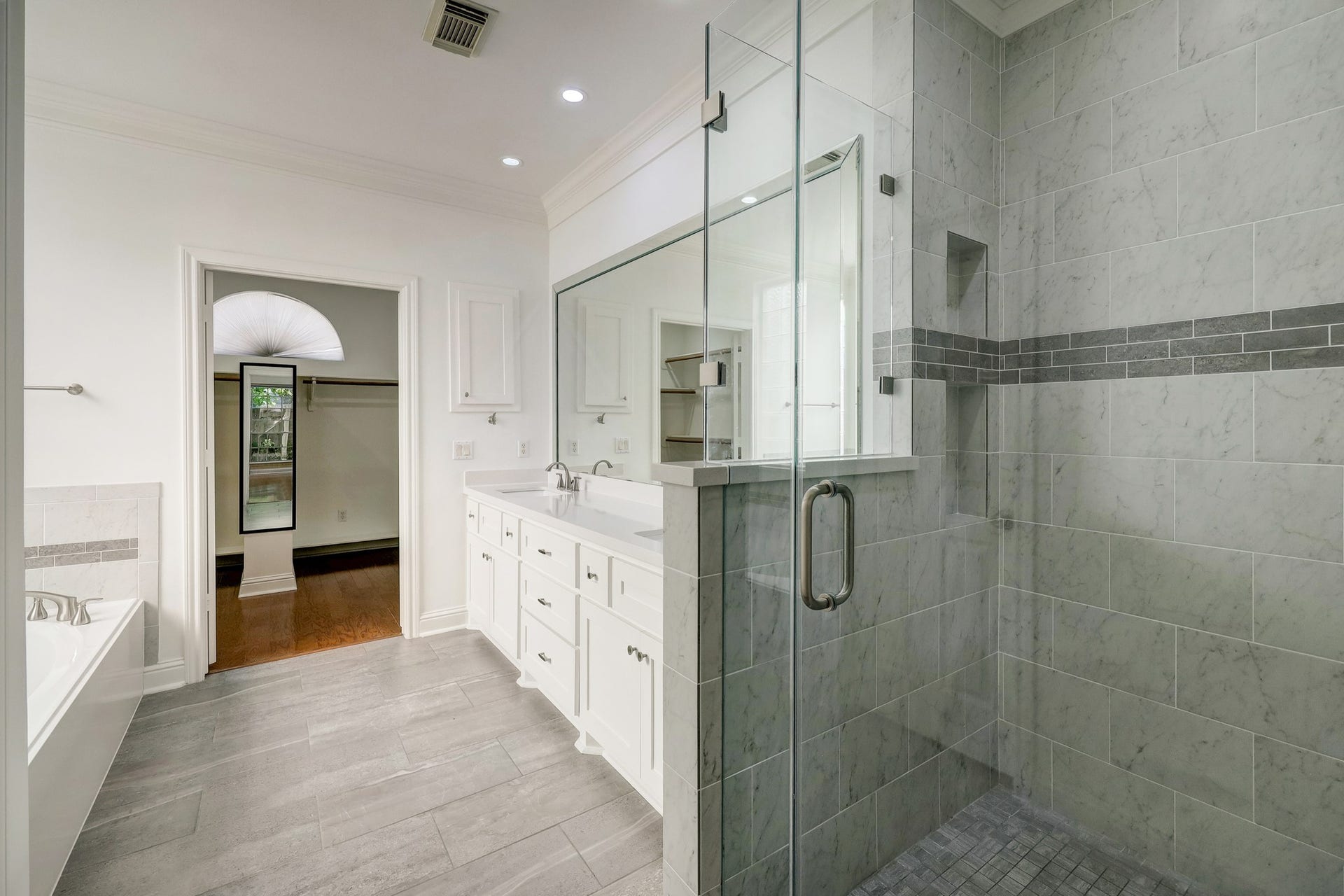 3608 Timberside Circle Drive, Houston, TX 77025 PRIMARY BATHROOM: Stylish and functional with a spacious walk-in shower, double vanity, and a generously sized walk-in closet tucked conveniently at the backperfect for organized living.