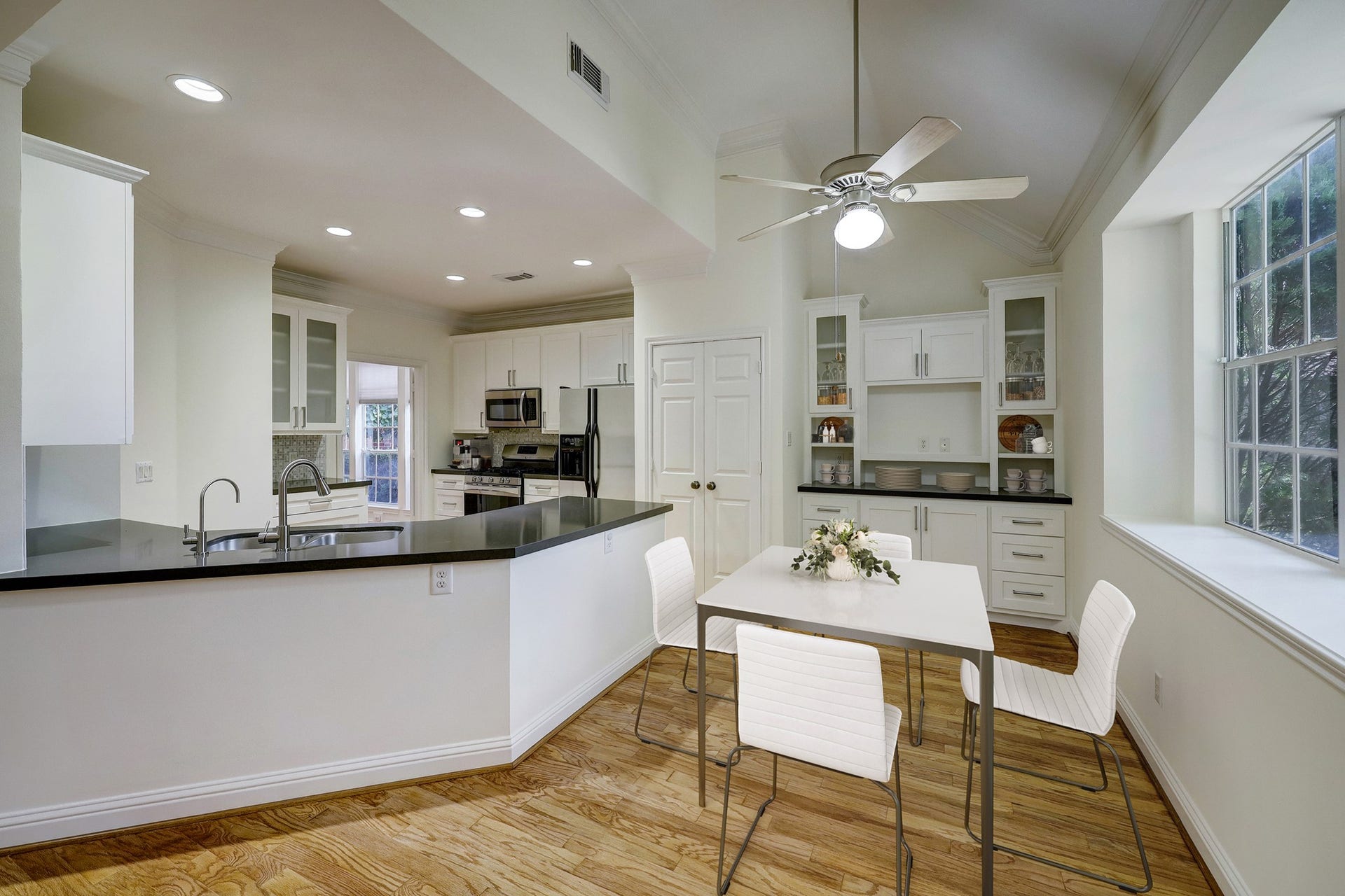 3608 Timberside Circle Drive, Houston, TX 77025 Kitchen & Breakfast Area: Bright and modern space featuring stainless steel appliances, granite countertops, and hardwood flooring. Virtual staging showcases layout potential and design inspiration.