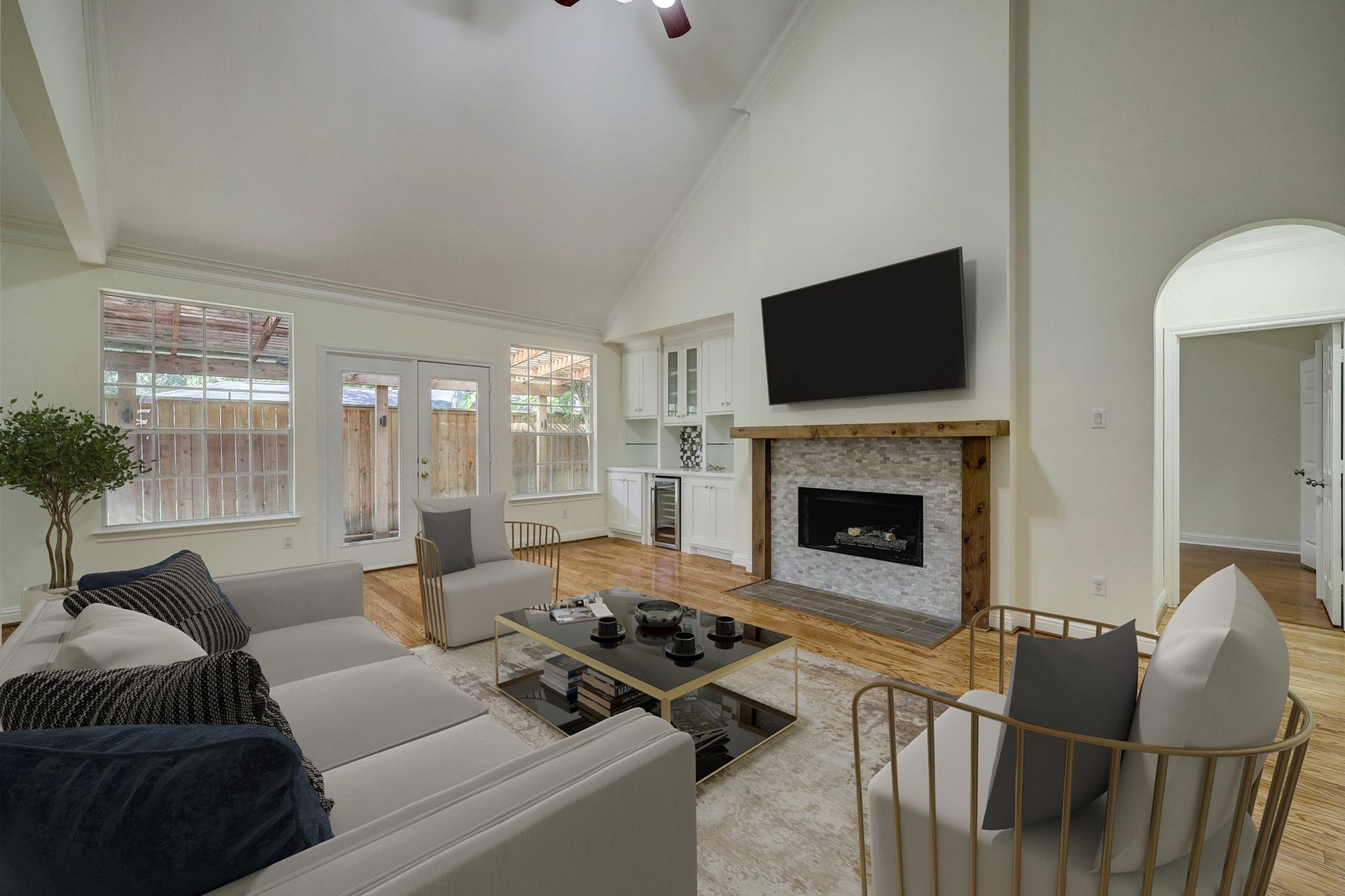 3608 Timberside Circle Drive, Houston, TX 77025 Living Room: Spacious and bright with high ceilings, hardwood floors, and a cozy fireplace. French doors and large windows bring in natural light, while virtual staging highlights the rooms potential for stylish and comfortable living. Virtually Staged