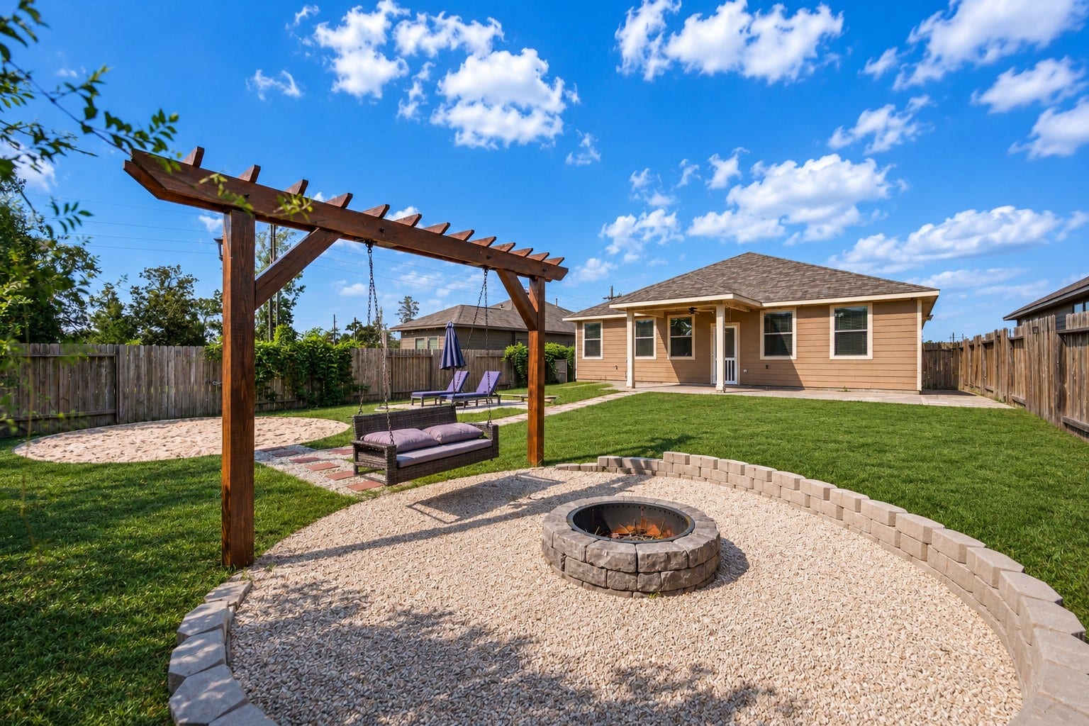 4707 Waukegan Road, Conroe, TX 77306 The backyard features a fire pit and stylish pergola, creating a welcoming outdoor setting with a clear view of the rear of the home.