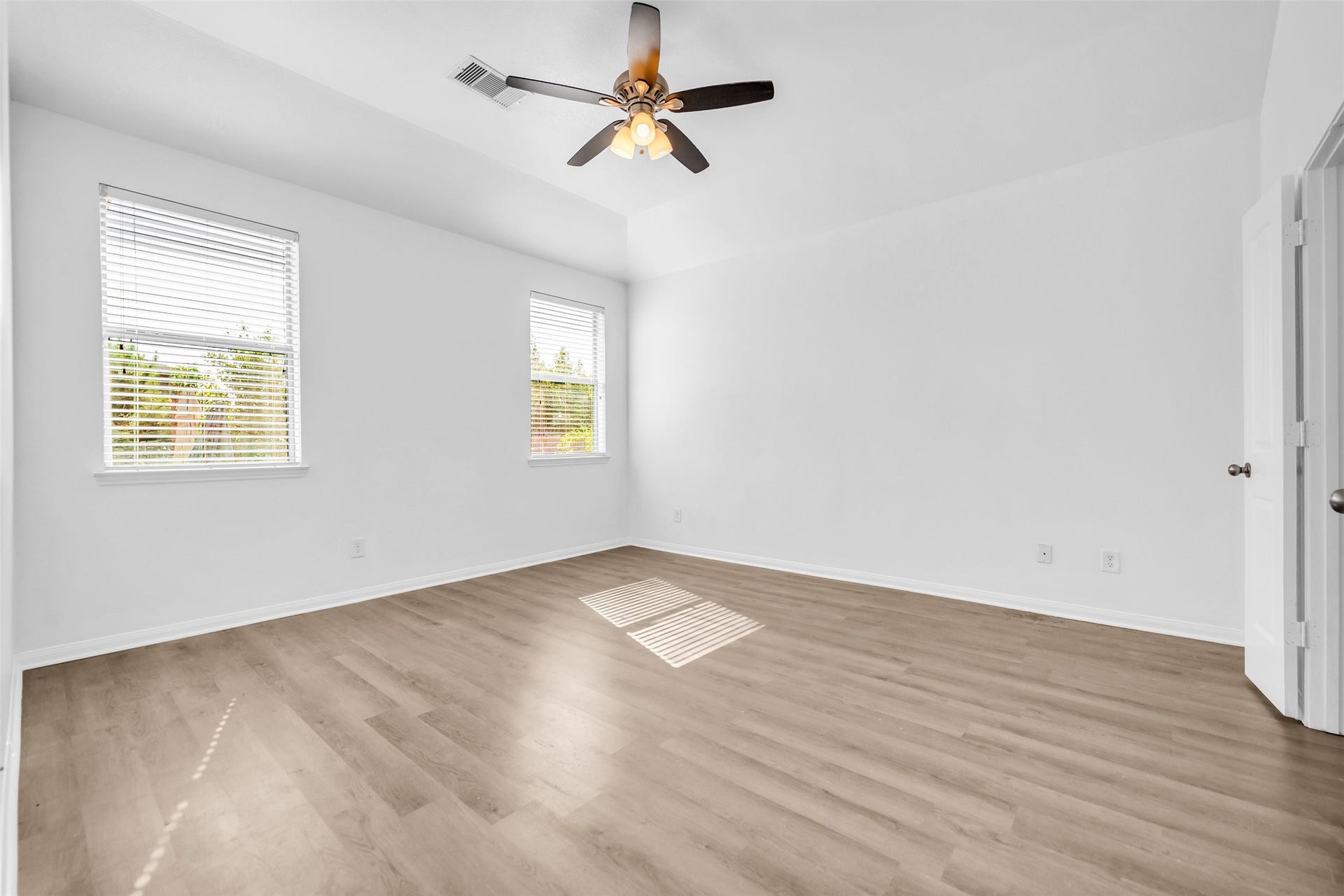4707 Waukegan Road, Conroe, TX 77306 This unfurnished view of the primary bedroom highlights its open layout, with multiple doors providing convenient access to other areas of the home.