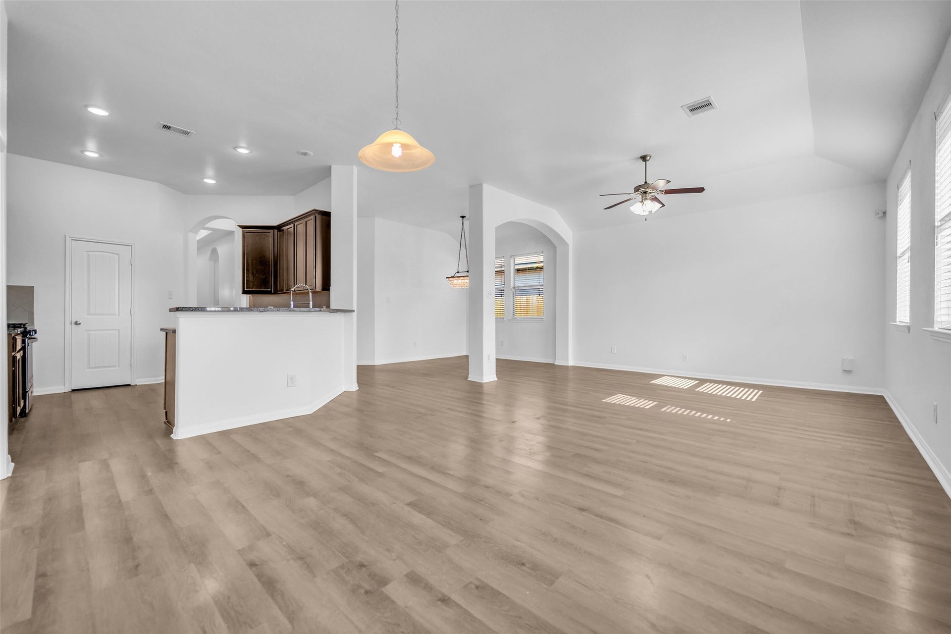 4707 Waukegan Road, Conroe, TX 77306 The living room features clean, durable vinyl flooring that continues seamlessly into the kitchen and dining area, creating a cohesive look throughout the main living space.