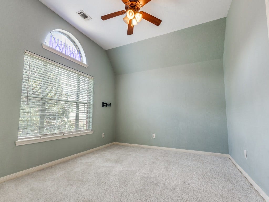 2811 Princeton Street, Houston, TX 77009 Upstairs just off the landing is a spacious room with a large arched window and blinds, neutral carpeting, offering a cozy and versatile space which can be utilized as a game room or office area.