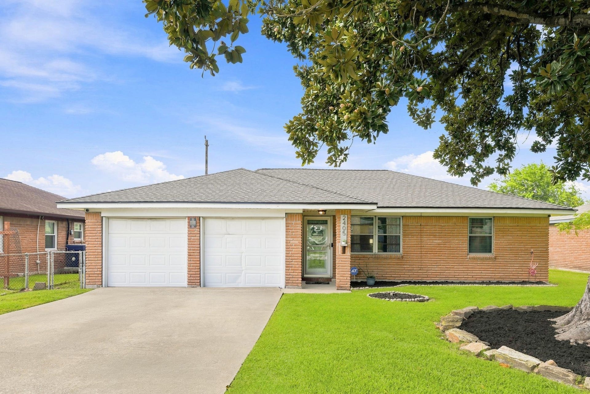 2405 Hillshire Drive, Deer Park, TX 77536 Charming single-story brick home with a double garage, well-maintained lawn, and mature trees, offering great curb appeal.
