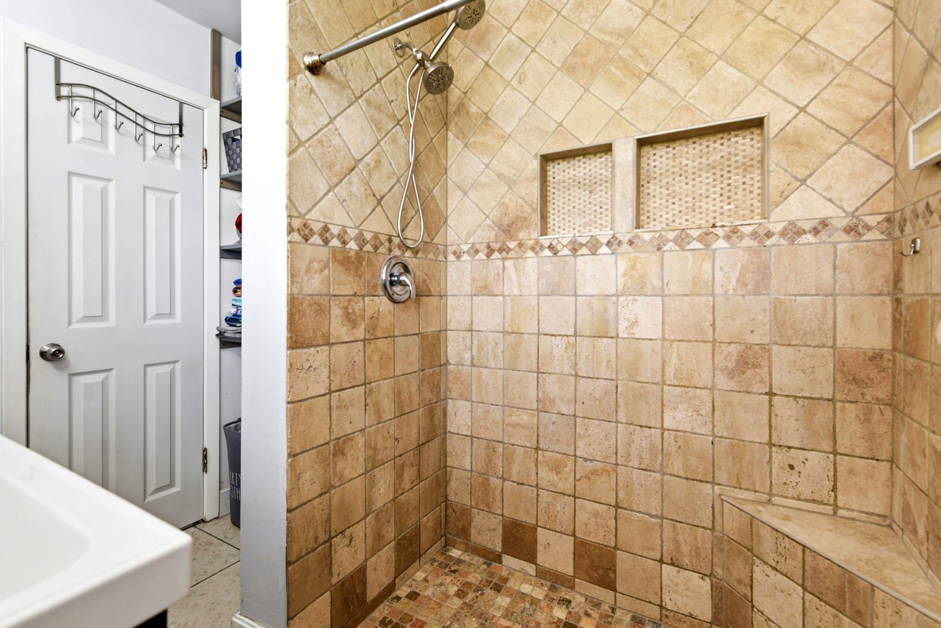 2405 Hillshire Drive, Deer Park, TX 77536 The bathroom features a spacious walk-in shower with elegant stone tile, dual shower heads, and built-in shelving for convenience.