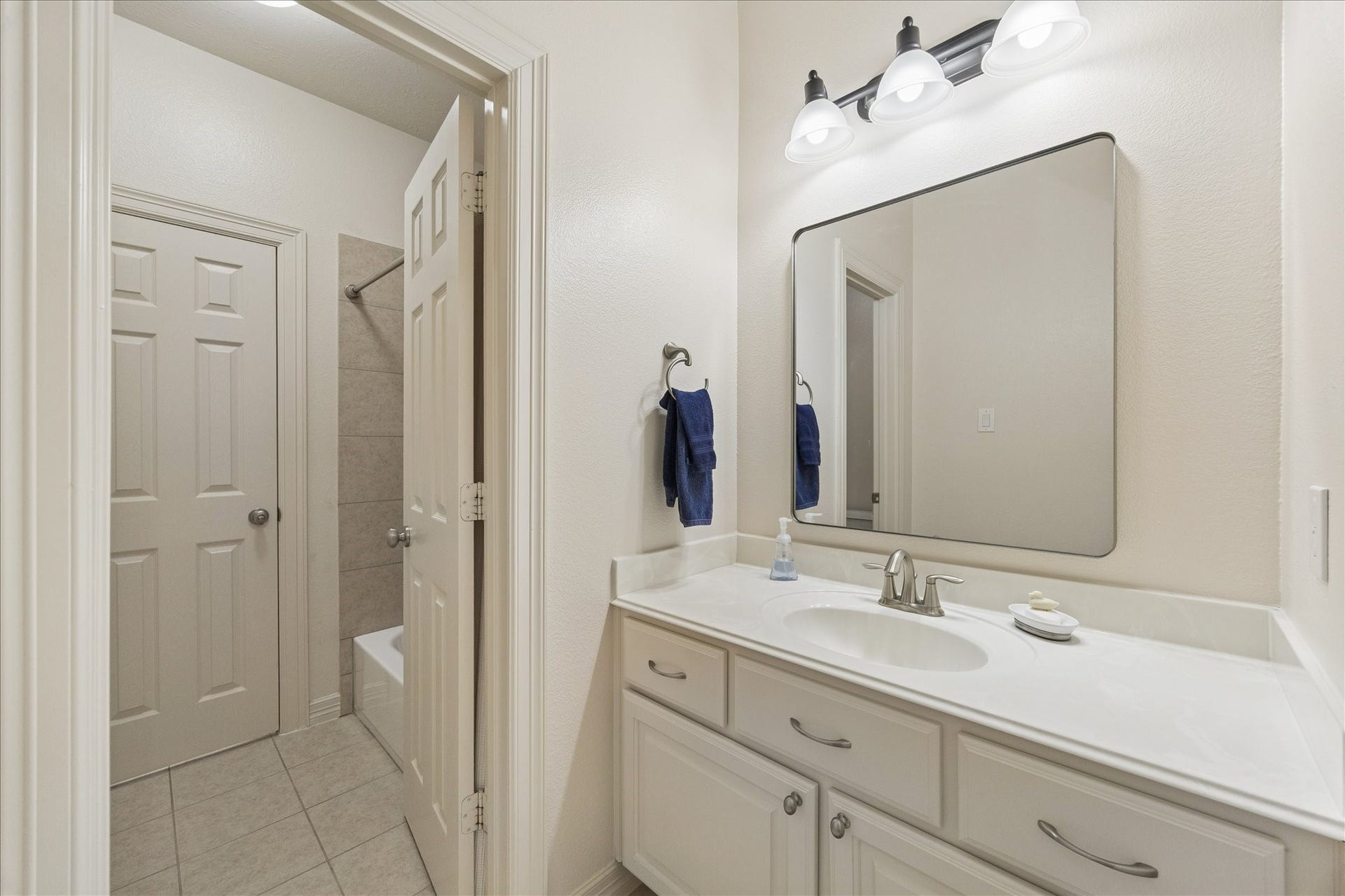 The tandem bath features a private sink for each bedroom.