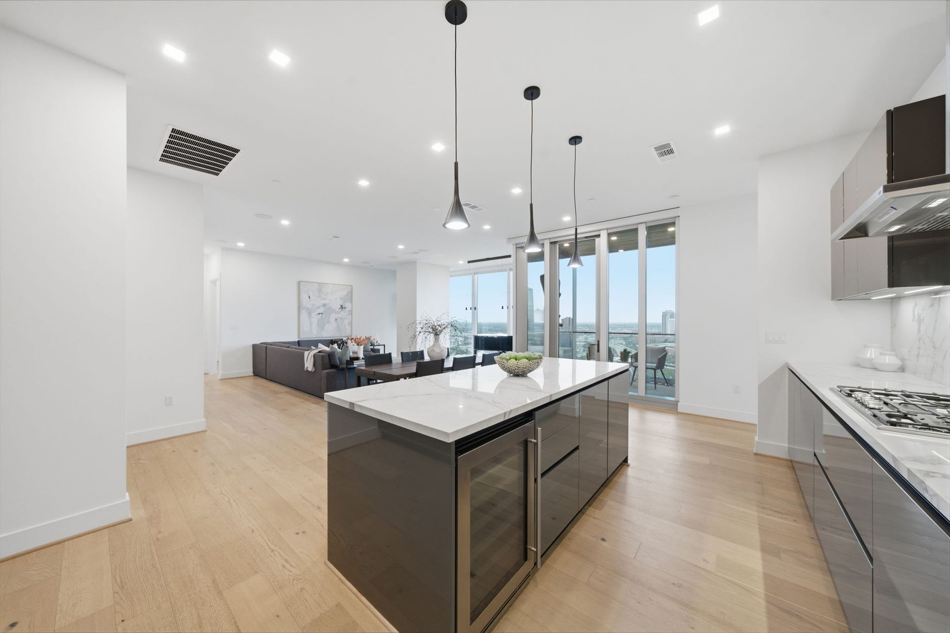 Thermador appliances, striking porcelain countertops and backsplash, a generous waterfall island, and a built in U Line wine cooler. Sophisticated finishes and thoughtful design create a space as functional as it is beautiful.