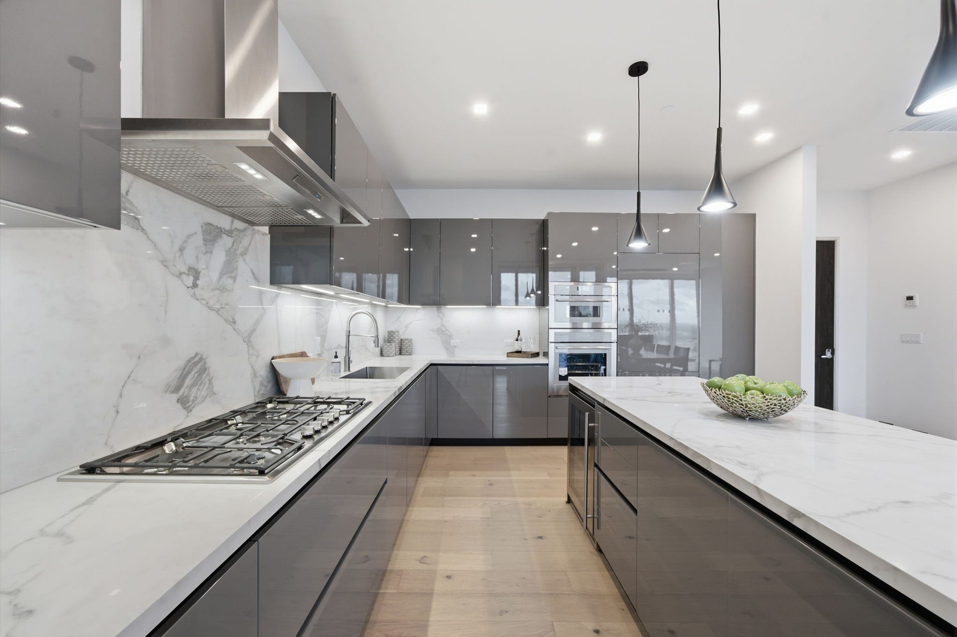 Chef inspired kitchen featuring sleek PEDINI cabinetry, Thermador appliances, porcelain surfaces, and an expansive island designed for effortless entertaining.