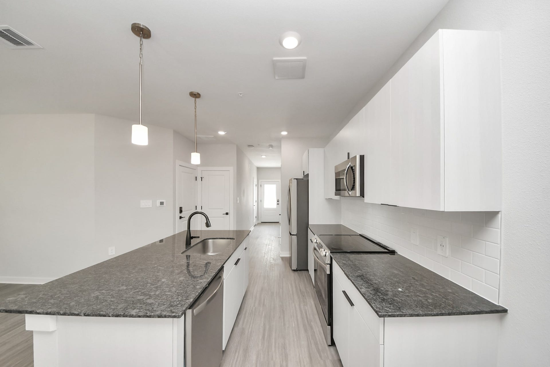 7711 Longmire Road, #199, Conroe, TX 77304 Boasting luxury finishes-stylish Island kitchen,granite counters,subway tile backsplash,ample custom cabinet space,stainless appliances,refrigerator,full size washer&dryer included,wood-like floors throughout,open concept floor plan.