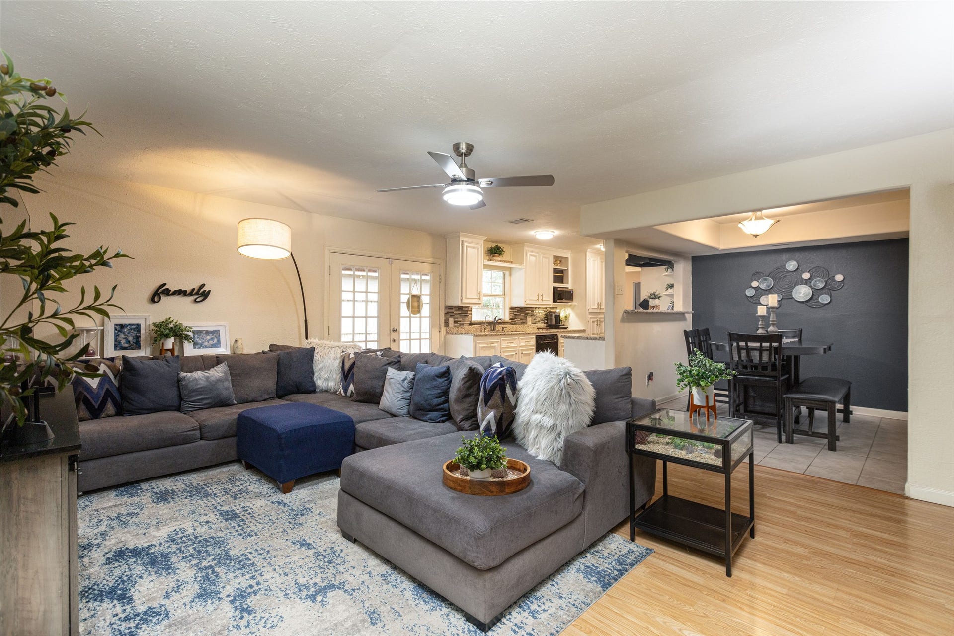 14007 Lorne Drive, Houston, TX 77049 Spacious open-concept living area featuring a cozy sectional sofa, stylish decor, and a seamless flow into the dining and kitchen spaces with modern finishes.