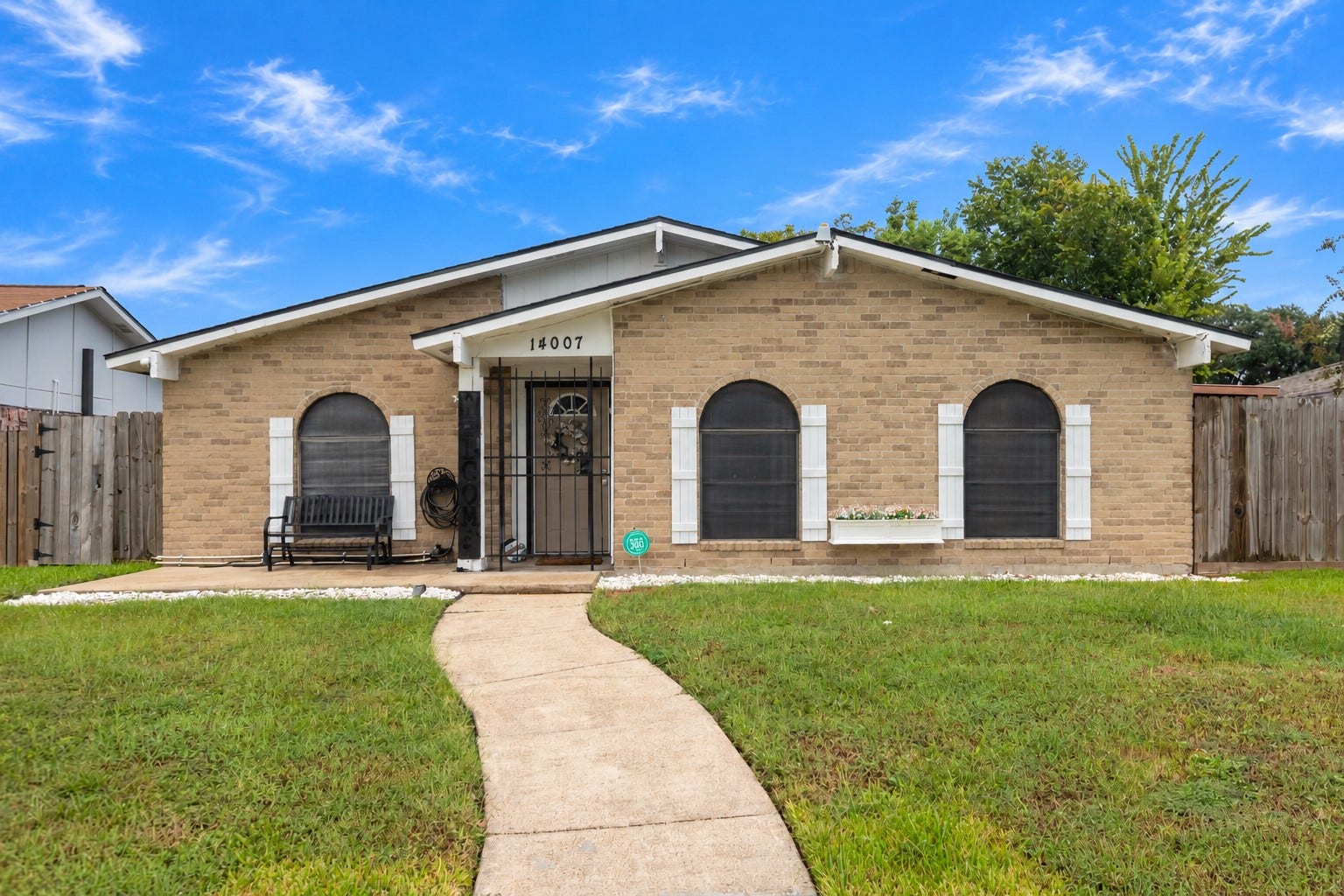 14007 Lorne Drive, Houston, TX 77049 Charming single-story home with a welcoming curved walkway, featuring a cozy front porch and beautiful arched windows, all surrounded by a well-maintained lawn.