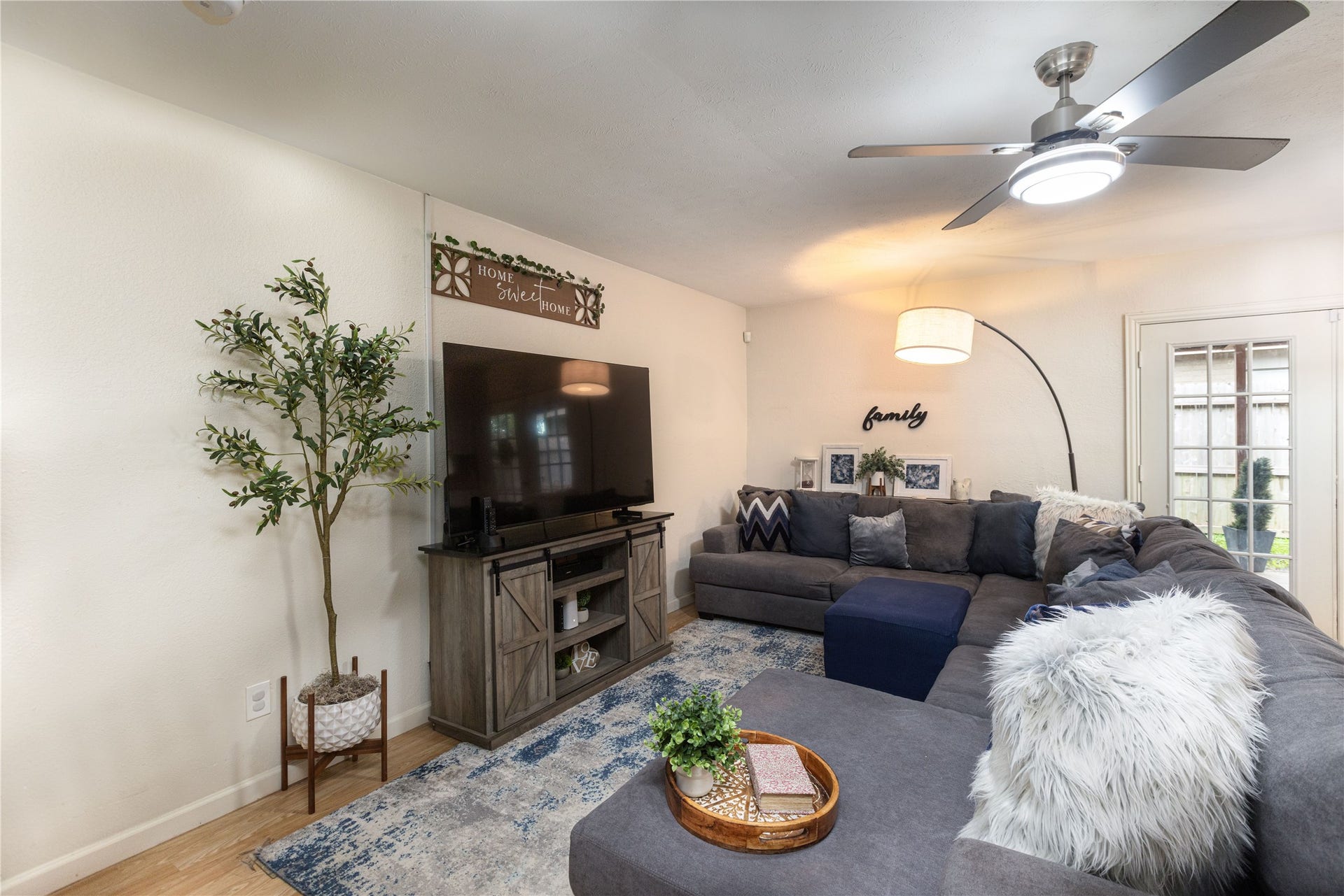 14007 Lorne Drive, Houston, TX 77049 Cozy living room featuring a large sectional sofa, modern ceiling fan, and stylish decor, perfect for family gatherings.