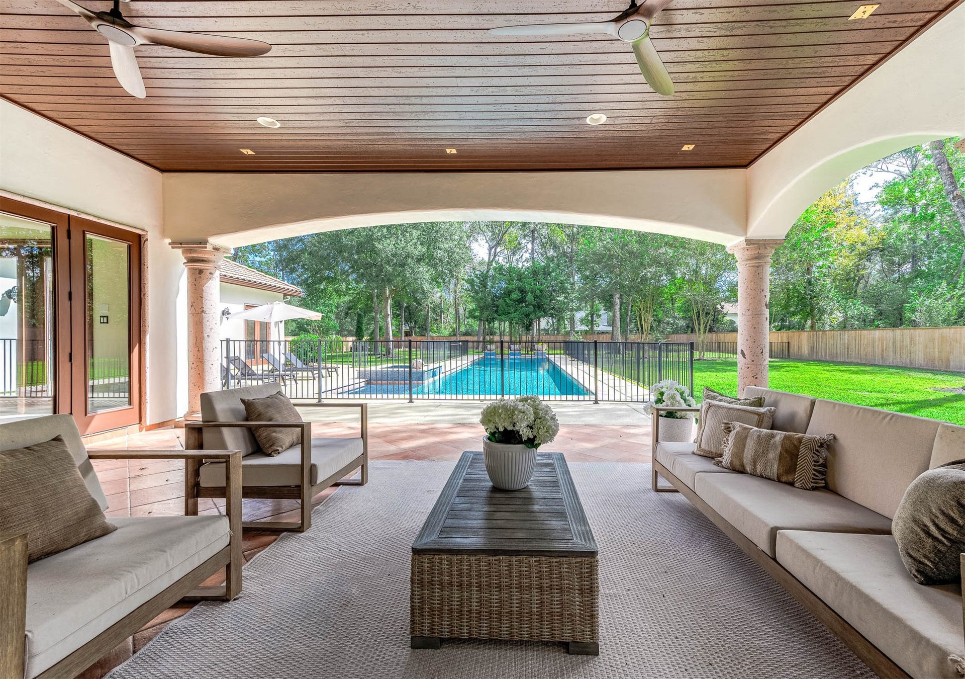 The covered patio offers shaded outdoor living with views of the lap pool and oversized backyard.