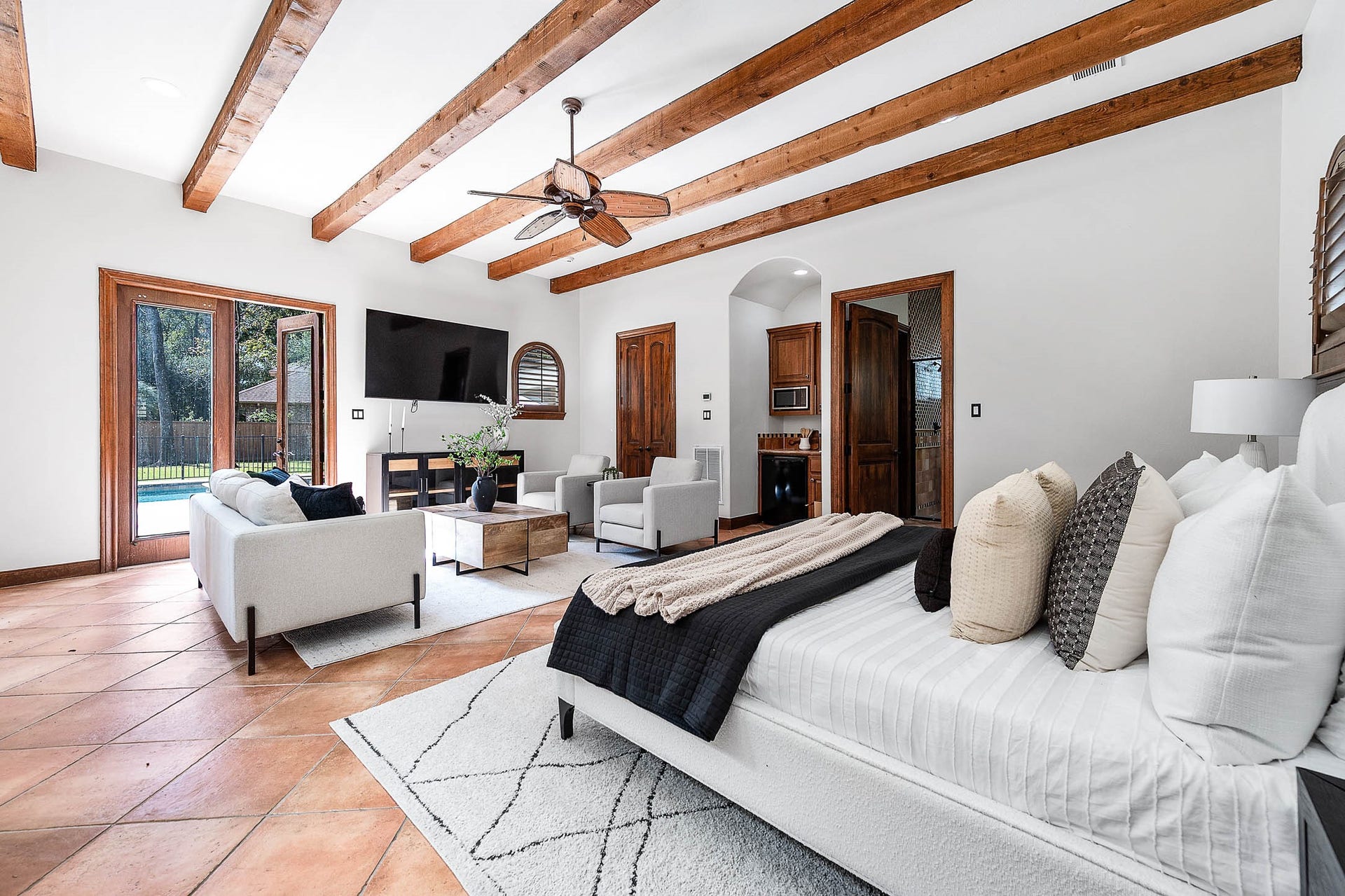 The guest suite bedroom features French doors opening directly to the pool.