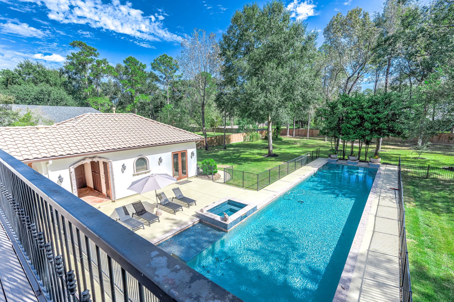 The resort-style backyard offers detached guest quarters alongside the pool and spacious pool deck.