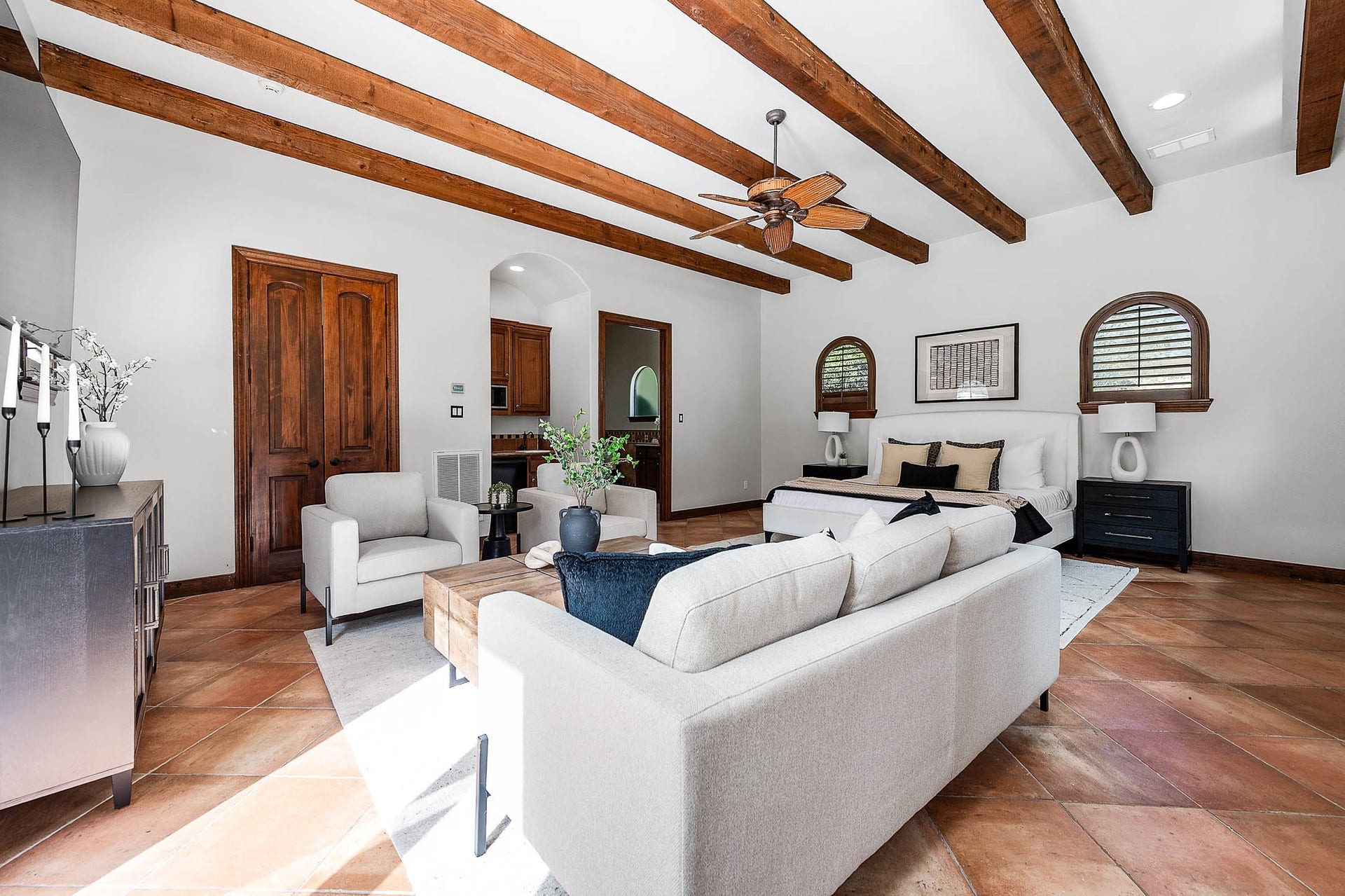 The detached guest suite offers its own kitchen, exposed wood beams, and terracotta tile floors.