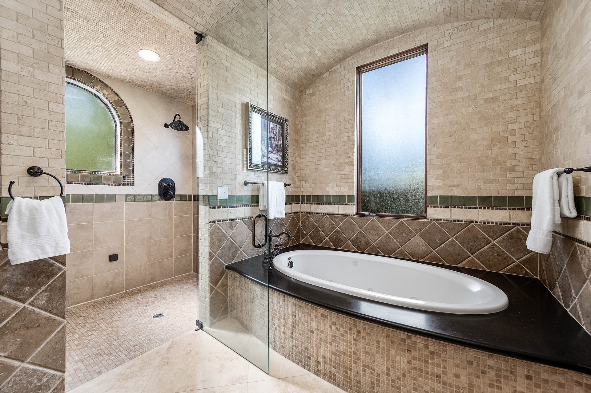 The steam shower is enclosed in frameless glass and finished with floor-to-ceiling tile.