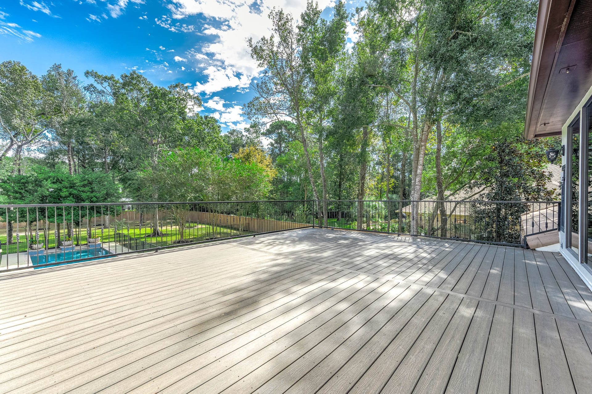 The expansive rooftop deck offers treetop views over the pool and backyard.