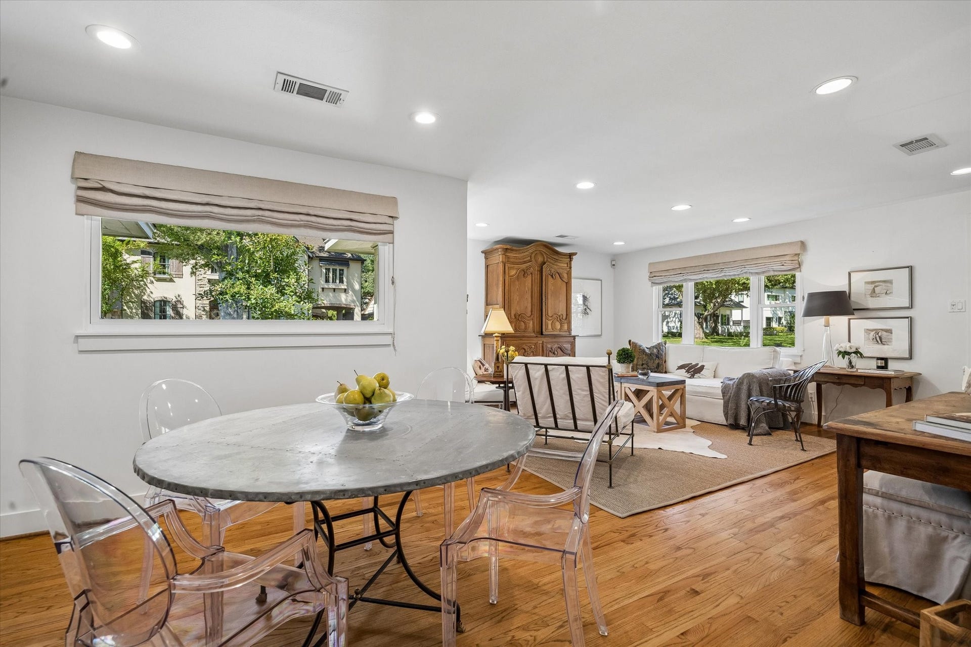 Bright and inviting, the open-concept living space features hardwood floors and large windows framing lush outdoor views.  The corner lot provides separation from neighboring homes, creating a wonderful sense of openness and privacy.