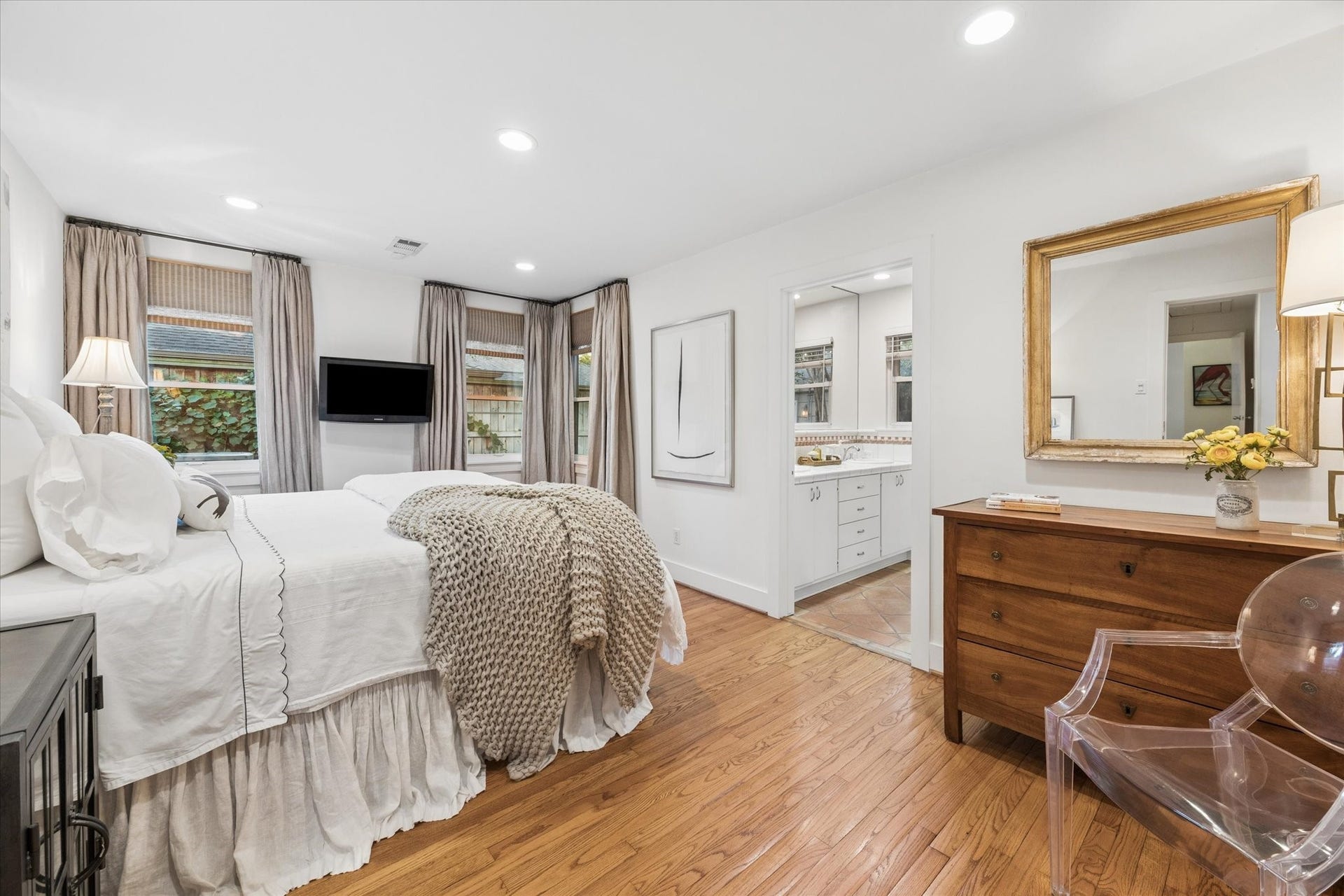 The primary bedroom has large windows with views looking out to the large lush back yard.