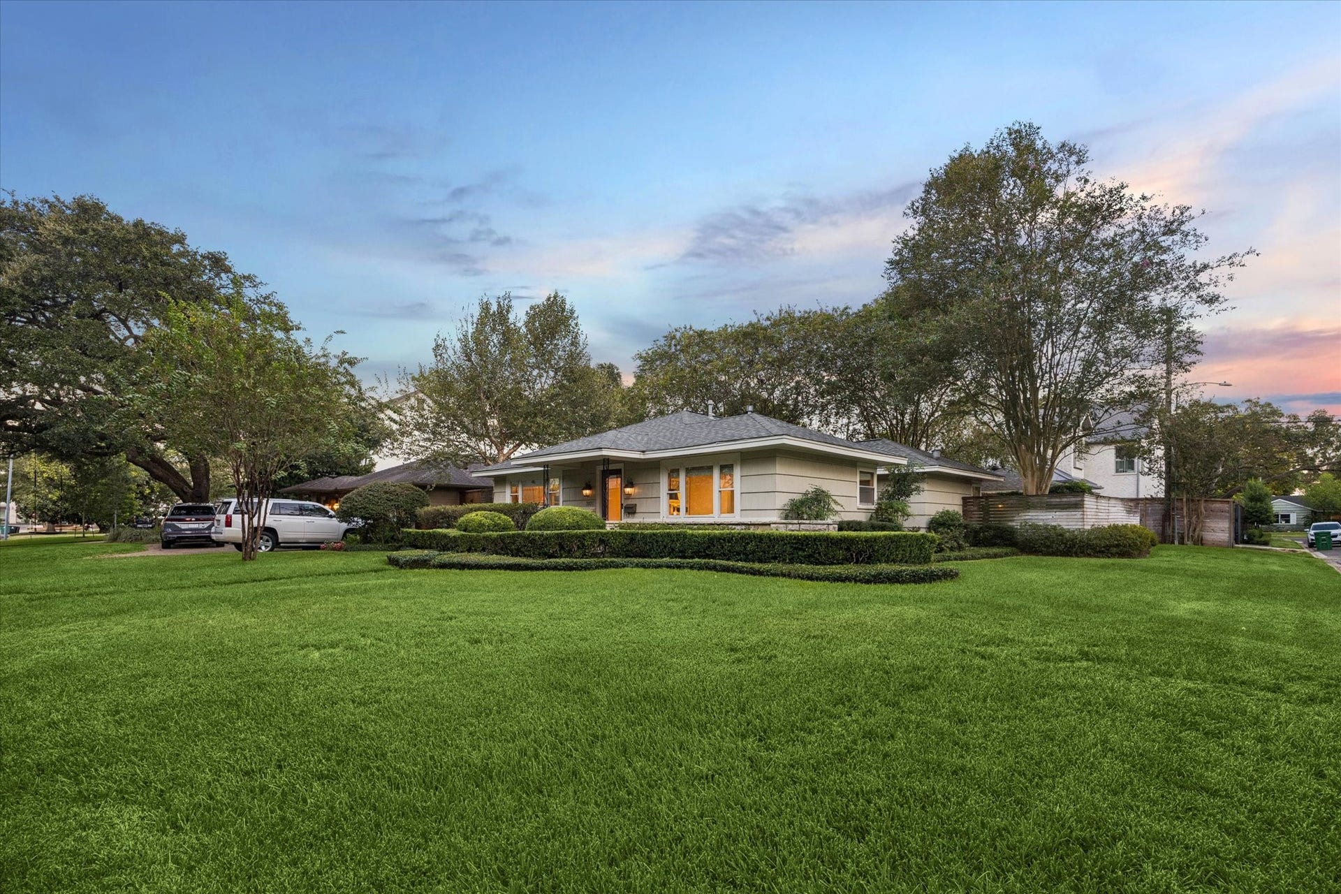 Charming single-story home set on a spacious corner lot, surrounded by mature trees and manicured landscaping, offering ample privacy and curb appeal.