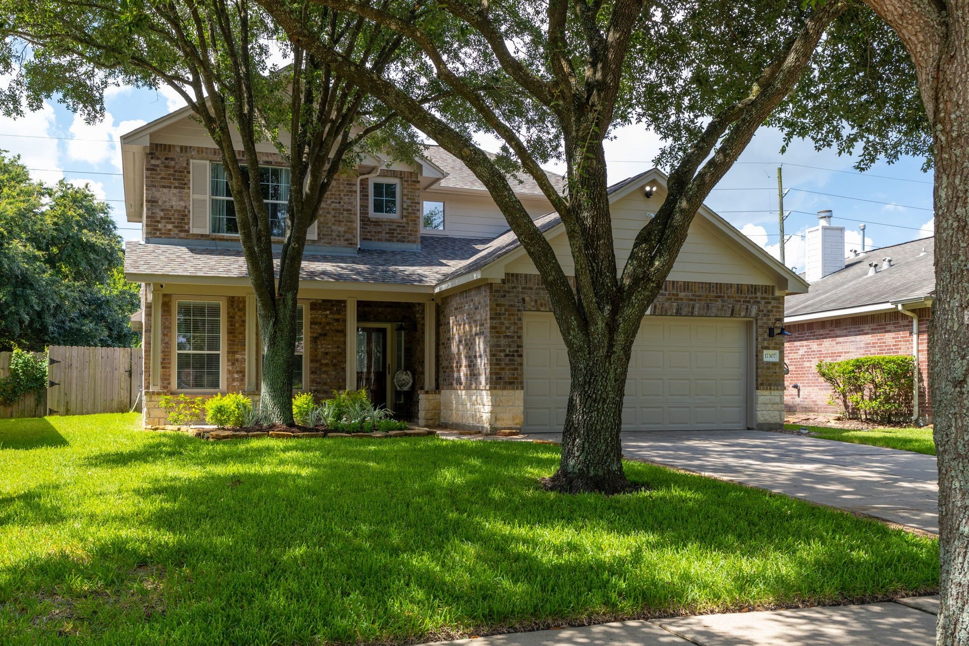 17307 Thicket Hollow Lane, Cypress, TX 77429 This is a charming two-story brick home with a well-maintained front yard and mature trees. It features a two-car garage and a welcoming front entrance.