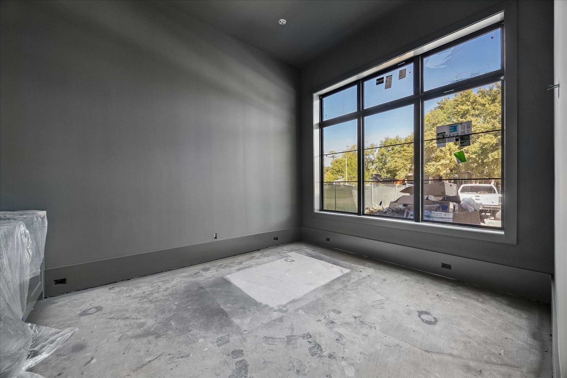 915 Lamonte Lane, Houston, TX 77018 Contrasting dark paint distinguishes the dedicated study from the Alabaster main living areas. A large front window and recessed ceiling add light and architectural definition. Builder dimensions identify an 11 x 14 study; flooring and final fixtures remain in progress.