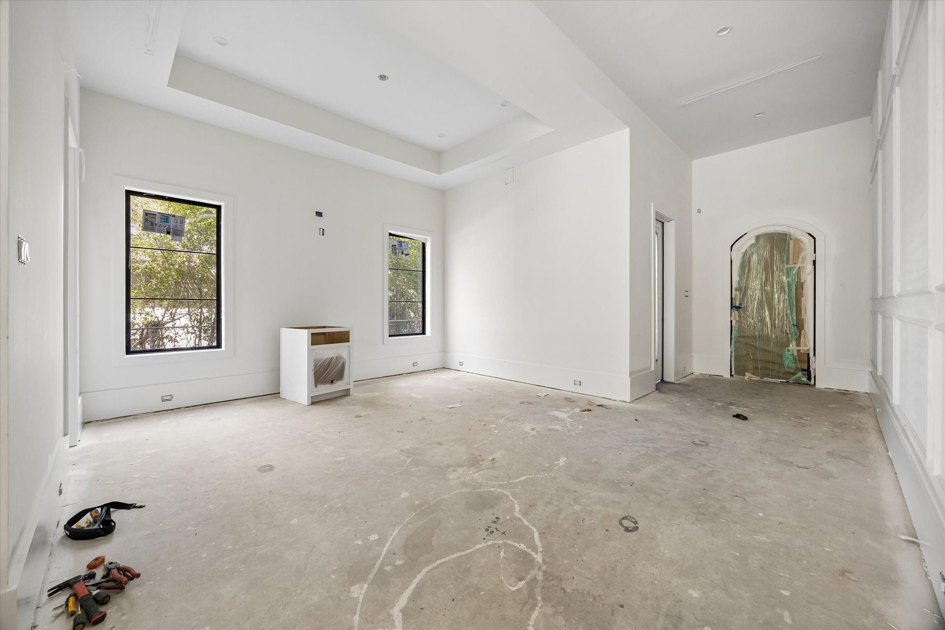 915 Lamonte Lane, Houston, TX 77018 Tray ceiling detail frames the dining room beside the arched front entry, while two tall windows bring daylight across the room. Alabaster was selected for the main walls and ceilings, providing a light backdrop for the architectural trim and planned European oak flooring.