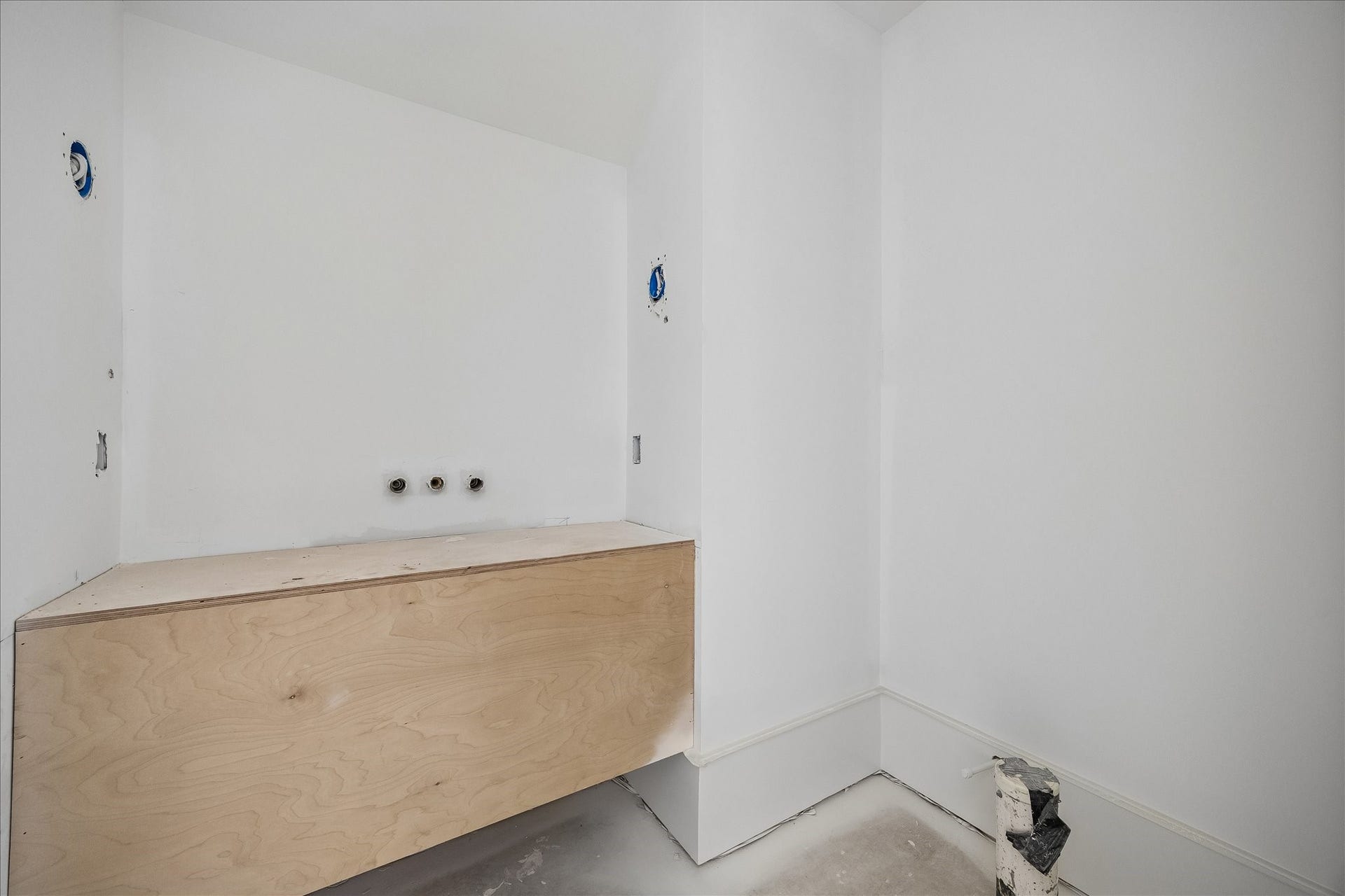 915 Lamonte Lane, Houston, TX 77018 Floating vanity cabinetry leaves the floor beneath open and gives this bath a simple profile. Wall plumbing rough ins and an adjoining recess show the layout before the basin, counter, mirror and fittings are installed. The photo records the current construction stage.