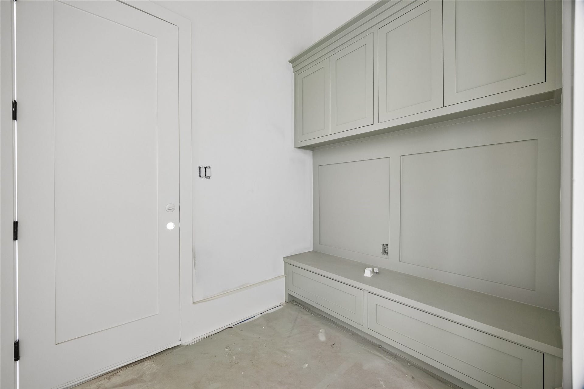 915 Lamonte Lane, Houston, TX 77018 Built in bench storage creates a practical drop zone beside the door, with drawers below and cabinets overhead. Paneled detailing ties the storage wall together, providing a place to set down daily items and organize supplies without extending into the circulation space.