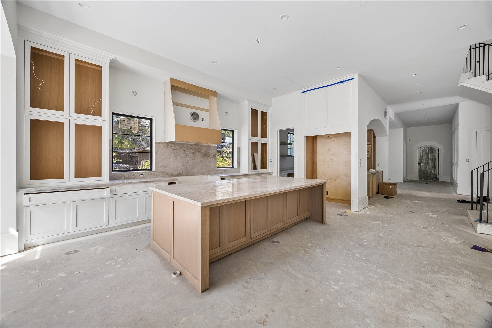 915 Lamonte Lane, Houston, TX 77018 10 x 5 island anchors the kitchen with a broad preparation surface and storage on multiple sides. Selected 2 cm Taj Mahal quartzite brings natural veining to the kitchen and bar counters, paired here with natural tone island cabinetry and painted perimeter cabinets.
