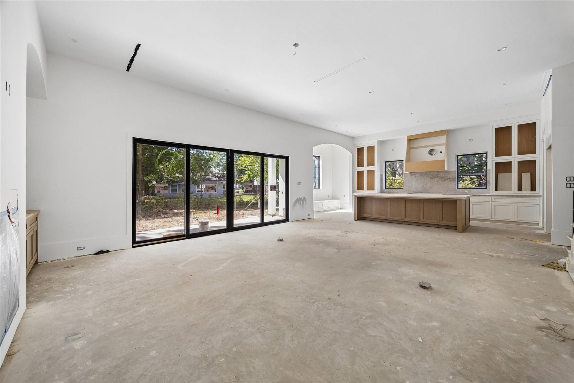 915 Lamonte Lane, Houston, TX 77018 Broad rear glazing links the open living area, island kitchen and breakfast nook with the backyard. Linear air vents keep the ceiling lines restrained. Builder specifications call for 12 foot downstairs ceilings, reinforcing the scale of these connected gathering spaces.