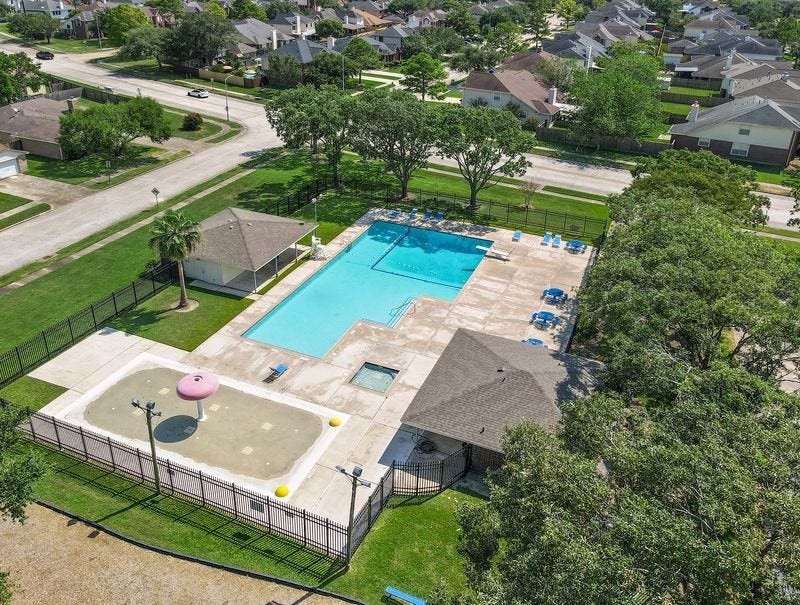 3802 Oakwilde Circle, La Porte, TX 77571 Another View of the Neighborhood Pool Area Featuring a Spacious Swimming Pool, Separate Splash Pad, Lounge Chairs, and Shaded Pavilion.