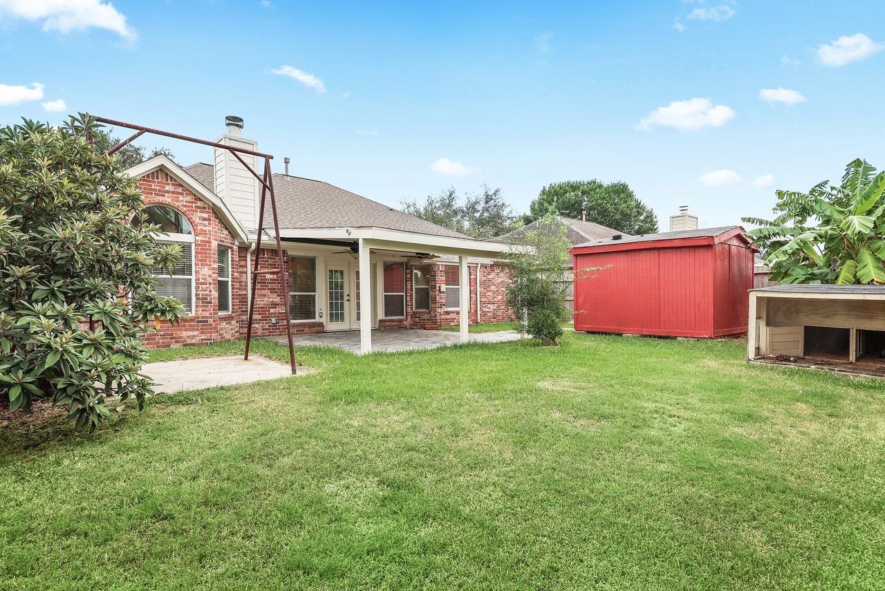 3802 Oakwilde Circle, La Porte, TX 77571 Generous Backyard Offers Plenty of Outdoor Space, an Expansive Covered Patio, and a 10x10 Storage Building for Added Convenience.