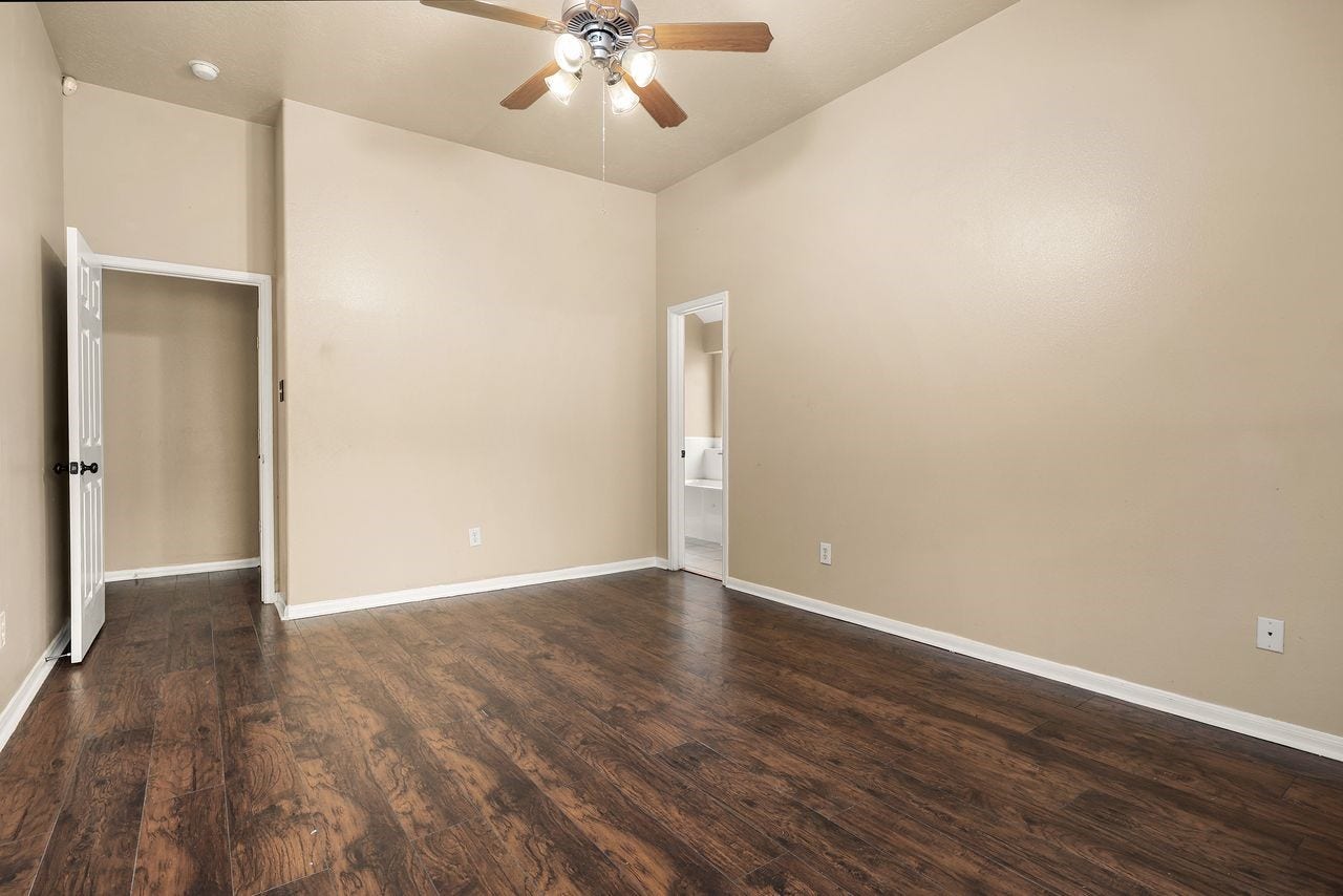 3802 Oakwilde Circle, La Porte, TX 77571 Another View of the Generous Primary Suite Highlighting the Beautiful Wood-Look Flooring, and Convenient Access to the Private Bath.