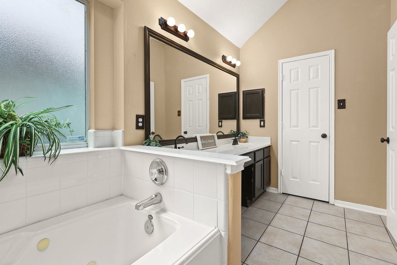 3802 Oakwilde Circle, La Porte, TX 77571 Primary Bath Features a Relaxing Jetted Tub, Dual-Sink Vanity, High Ceiling, and Natural Light.
