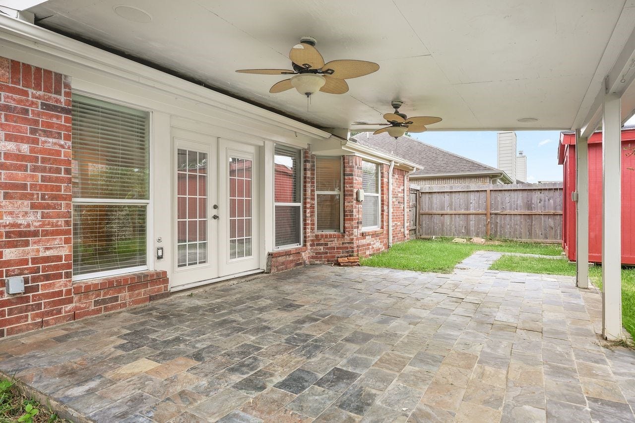 3802 Oakwilde Circle, La Porte, TX 77571 Expansive Covered Patio with Slate Flooring and Two Ceiling Fans, Perfect for Outdoor Relaxation and Entertaining!