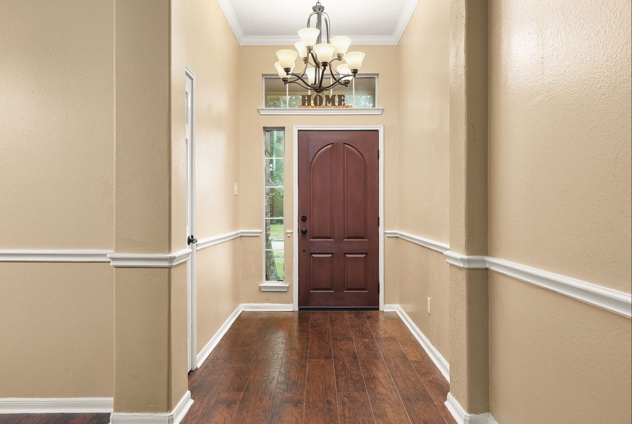 3802 Oakwilde Circle, La Porte, TX 77571 Welcoming Entry Features Beautiful Wood-Look Flooring, Elegant Chandelier, Decorative Chair Rail Molding, and High Ceiling.