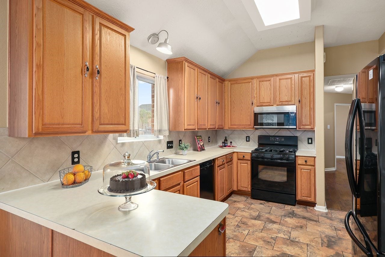 3802 Oakwilde Circle, La Porte, TX 77571 Spacious Kitchen Features Abundant Cabinet and Counter Space, Breakfast Bar, Pantry, and Black Appliances.