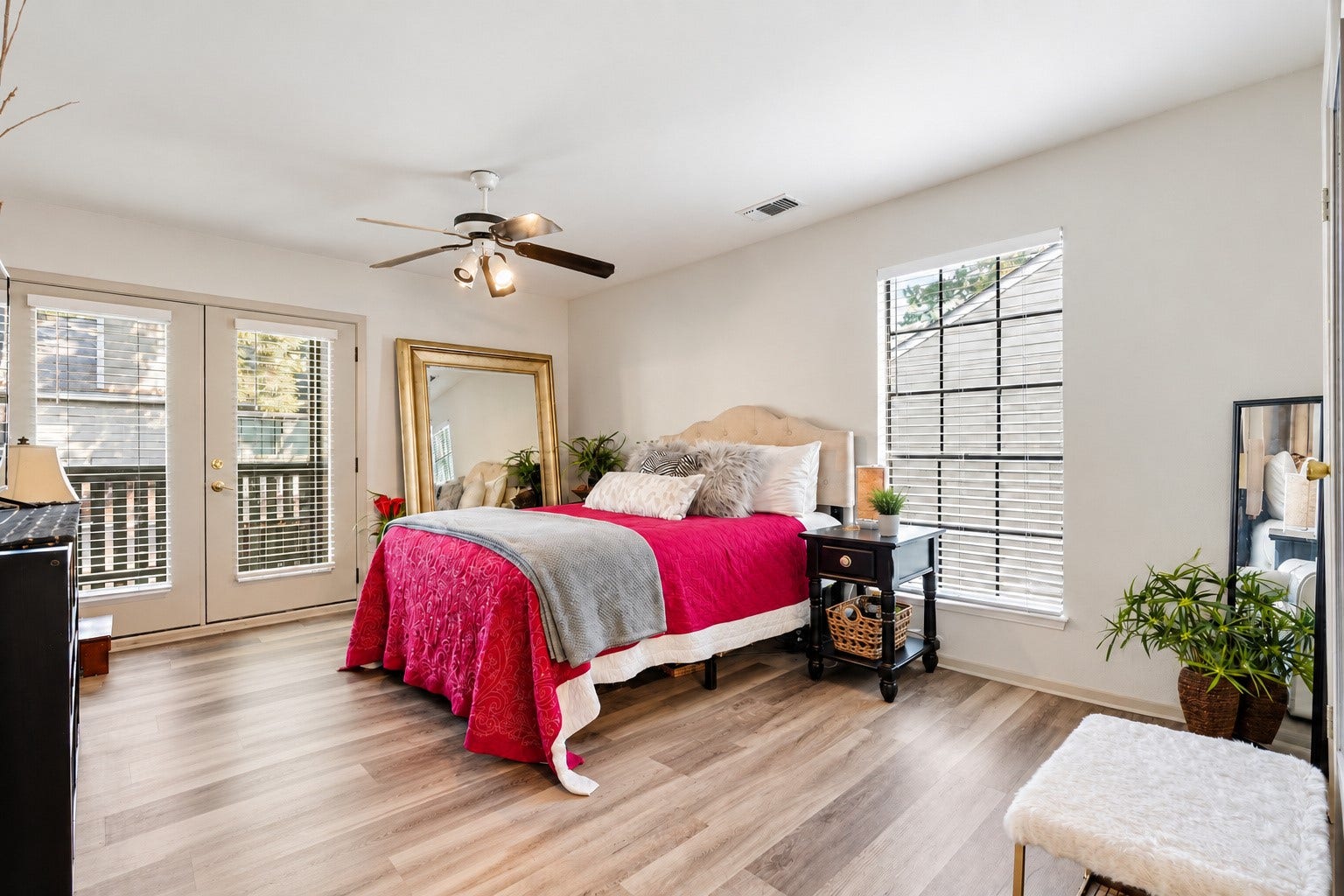 Spacious primary bedroom with natural light and French doors leading to a private balcony.