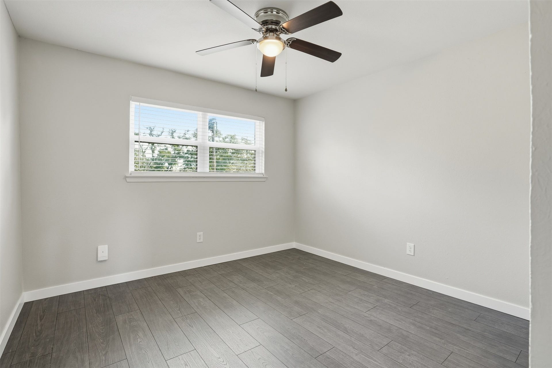 Bright secondary bedroom with natural light and a versatile layout.
