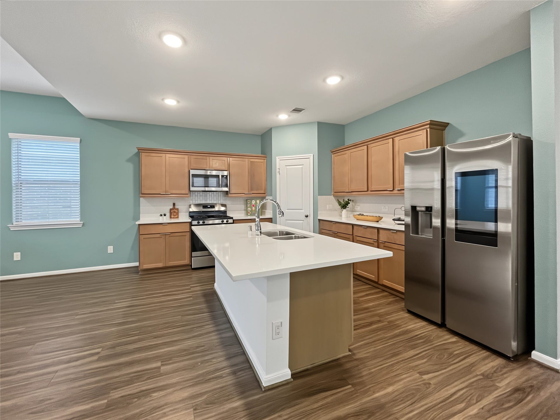 1423 Cecilia Vines Drive, Conroe, TX 77301 The kitchen is loaded with stainless steel appliances and quartz countertops.