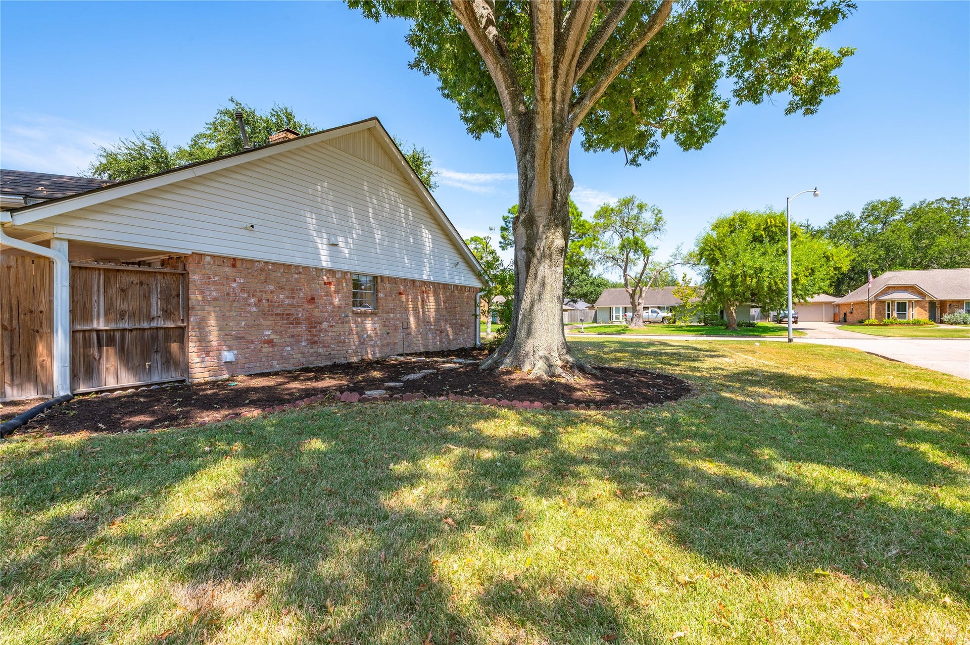 501 Audubon Street, League City, TX 77573 Additional side yard with landscaping beds and mature tree.