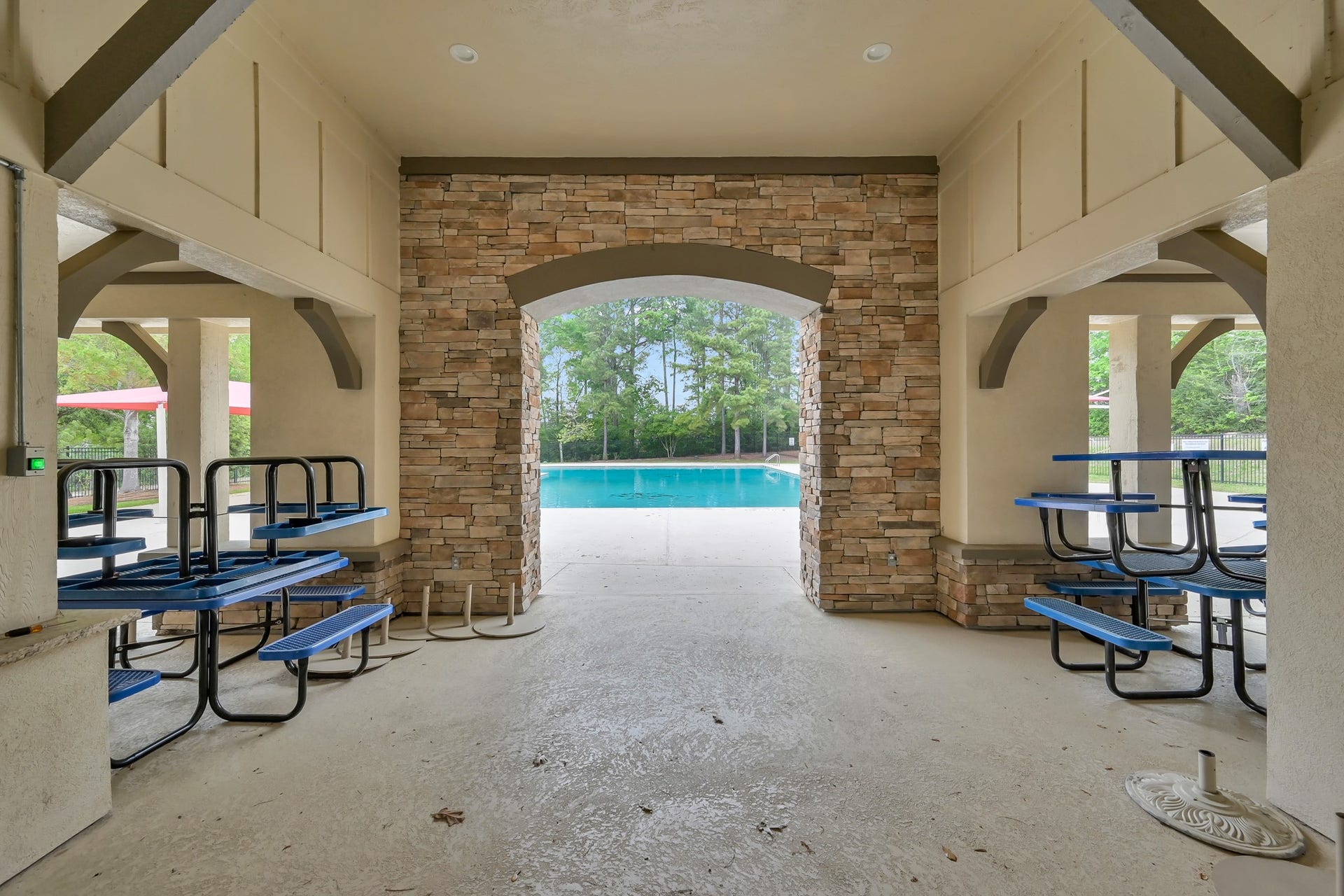 Graystone Hills community poolside pavilion featuring covered seating, picnic tables and beautiful stone accents, perfect for relaxing in the shade after a swim!