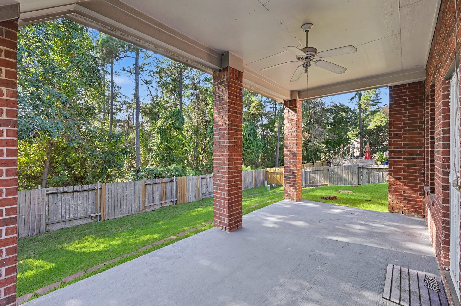 Expansive covered back patio with ceiling fan, overlooking the private, fully fenced backyard with mature trees and no rear neighbors. Perfect for relaxing or entertaining!